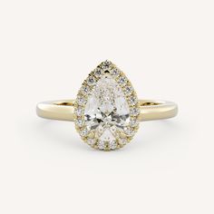 a pear shaped diamond engagement ring set in yellow gold