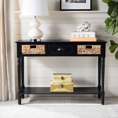 a black console table with two baskets on top and a lamp next to it in a living room