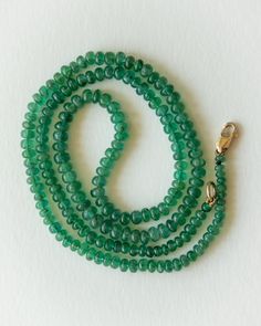 Natural Emerald beads on a hand-strung 16.75" inch necklace. Weighing 41 carats total. With a solid 14k yellow gold clasp. The Emerald beads are slightly graduated, and round in shape. Lively Green colour, with nice clarity. This strand is lovely quality! The birthstone for May, Emeralds have been coveted around the world for Millenia. A favourite of Cleopatra, its easy to understand how we've become captivated by the rich Green hues through time. Wear them alone, or mixed with your other neckla Single Strand Round Beaded Emerald Necklaces, Faceted Emerald Necklace With Round Beads, Emerald Faceted Beaded Necklaces, Faceted Round Beads Emerald Necklace, Luxury Polished Beads Emerald Necklace, Emerald Bead, Green Hues, Rich Green, Green Colour