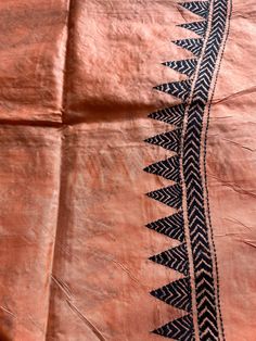 an orange cloth with black and white designs on the side, sitting on top of a table