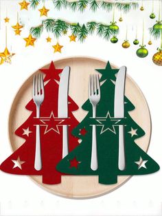 two christmas trees on a plate with forks and spoons in front of the tree