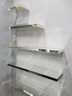 three glass shelves on the side of a wall