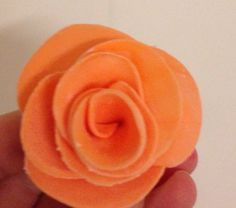 an orange flower that is in someone's hand