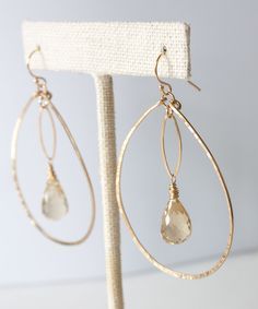 Our Genevieve Marquis Drop Earrings stand apart from the crowd. Featuring light reflecting faceted Beer Quartz stones floating inside sparkling hand forged gold fill teardrops, this style will add a striking statement to your look. All gold elements crafted from high quality 14k gold fill that will not wear off or discolor over time. MATERIALS Faceted Beer Quartz | Hand forged 14k gold fill teardrops and ear wires MEASUREMENTS2" drop from ear | 1.6" width approx. ORIGIN Handcrafted in Florida ST Earrings Stand, Beaded Earrings Diy, Earring Stand, Handmade Wire Jewelry, Feature Light, Quartz Stone, Diy Earrings, Hand Forged, Teardrop Earrings