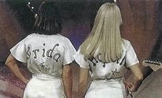 two women in white dresses standing next to each other with their backs turned towards the camera