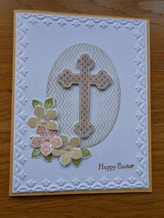 an easter card with a cross and flowers on the front, sitting on a table