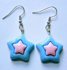 pair of blue and pink star shaped earrings on white surface with silver earwires