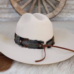 The Falcon Western Feather Hat Band boasts a width of 4 cm and an approximate length of 58 cm, excluding the leather ties. Designed to fit most sizes, this adjustable hat band features leather ties for a secure and comfortable fit. Please note that this product includes one single hat band and does not come with a hat. The feather detailing adds a bold touch of western flair, making it a distinctive addition to any hat. Adjustable Country Fedora For Kentucky Derby, Adjustable Felt Hat For Kentucky Derby Country Events, Adjustable Hat Bands For Country Events In Fall, Adjustable Short Brim Top Hat For Rodeo, Adjustable Country Hat Bands For Fall, Adjustable Short Brim Hat Bands For Ranch, Adjustable Brown Top Hat For Ranch, Adjustable Fedora For Country Events, Country Style Fedora With Adjustable Curved Brim