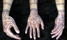 two hands that have tattoos on them