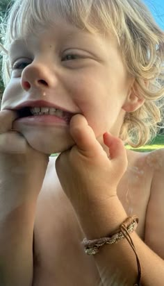 a little boy that is sitting down with his hands on his face and mouth open