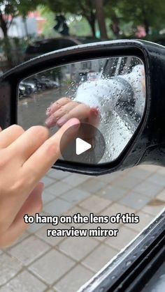 someone is holding their hand out the side view mirror