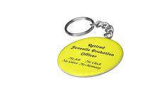 a yellow keychain with the words retired juvenile population officer written in black on it