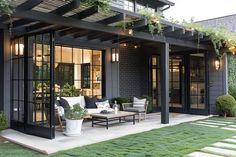 an outdoor living area with couches, tables and potted plants