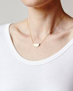 ◒ FELM - Brass half moon necklaceDETAILS AND FINISHINGS▴ Each piece is handmade.  Please expect slight variations between each item and the photograph in the listing.▴ Raw brass pendant is polished with a protective wax.▴ Chain is 24K gold plated brass.DIMENSIONS▴ Pendant Dimensions:  7/8" x 3/8"▴ Chain Length: 16" or 18"▴ Chain thickness: 1mm ball chainCARE▴ Handle with care and avoid striking against hard surfaces.▴ By nature, all brass will eventually darken over time but can be maintained an Minimalist Circle Jewelry In 14k Gold Filled, Minimalist 14k Gold Filled Round Pendant Jewelry, Everyday Circular Brass Necklace, Everyday Brass Necklace, Minimalist Gold Jewelry With Moon Charm, Minimalist Circle Necklace For Everyday, Adjustable Round Minimalist Necklace, Everyday Crescent Necklace With Delicate Chain, Minimalist Round Adjustable Necklace