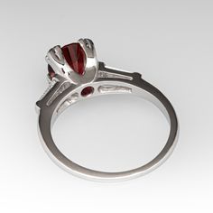 This lovely vintage ring is centered with one (1) round brilliant cut natural rhodolite garnet set into a four-prong setting. The shoulders of the ring are each accented with one (1) channel set, tapered baguette cut diamond. The ring measures 7.6mm at the top, rises 8.1mm above the finger, tapering to 1.2mm wide and 1.1mm thick at the base of the shank. It is currently a size 6.25. Formal Garnet Ring With Center Stone, Elegant Garnet Ring With Prong Setting, Elegant Garnet Round Cut Rings, Formal Garnet Rings With Accent Stones, Elegant Garnet Ring With Center Stone, Elegant Garnet Birthstone Ring With Center Stone, Luxury Garnet Ring With Center Stone, Classic Ruby Promise Ring With Center Stone, Luxury Garnet Rings With Accent Stones