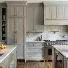 a kitchen with marble counter tops and gray cabinets