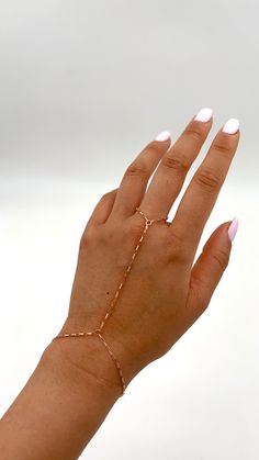 "Shiny and chic chain is beautifully crafted to accentuate your hand.  This chain is dainty yet sturdy. Materials used are 14k Gold Filled, 14k Rose Gold Filled, and Sterling Silver.  You may absolutely expose to water, and it will keep its color.   ::Color/ Materials Options:: Gold (14k Gold Filled) Rose Gold (14k Rose Gold Filed) Silver (Sterling Silver) ::Sizing:: Small: ring chain fits up to Size 10, top of hand length 2.75\", wrist fits 6\"-7\" Medium: ring chain fits up to Size 10,  top of hand length 3\", wrist fits 6\"-7\" Large: ring chain fits up to size 12,  top of hand length 3.25\", wrist fits 6.5\"-7.5\" Custom: Please message us.  We are happy to customize your hand chain.  Have your wrist size (inches), and Ring size ready.  Outside of USA, you can measure with cm around yo Party Jewelry With Delicate Link Chain, Party Jewelry With Delicate Chain Link, Adjustable Rose Gold Bracelet With Gold Chain, Delicate Chain Rose Gold Metal Jewelry, Dainty Chain Jewelry For Party, Rose Gold Metal Jewelry With Chain, Pink Gold Jewelry With Adjustable Chain For Gift, Rose Gold Delicate Chain Fine Jewelry, Minimalist Link Jewelry For Party