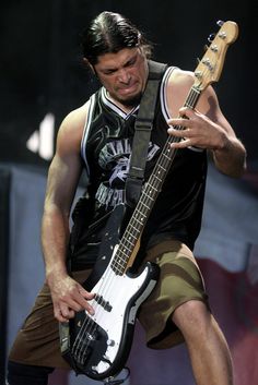 a man holding a guitar while standing on top of a stage