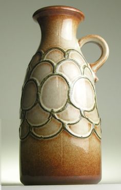 a brown and white vase sitting on top of a table