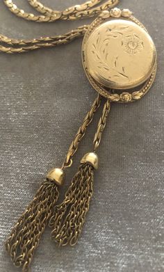 "Vintage A-C 12K Gold-filled Locket Tassel Lariat Pendant Necklace. Size: Necklace- 29\"x 3/16\"(3mm). Locket: 1\"x1 1/4\" round. Markings: A-C 1/20 12KT GF. Beautiful. Sold as is. Pre-Owned." Antique Gold Lariat Necklace, Antique Lariat Jewelry Gift, Vintage Engraved Lariat Jewelry, Vintage Lariat Jewelry With Adjustable Chain, Antique Lariat Necklace Gift, Antique Lariat Necklace As Gift, Antique Lariat Necklace For Gift, Vintage Lariat Jewelry, Adjustable Vintage Lariat Necklace