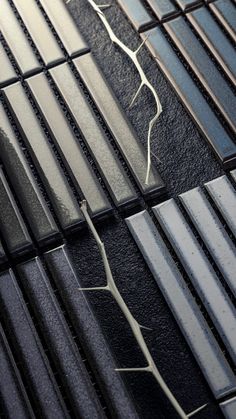 the metal grate has broken into pieces and is black with white lines on it