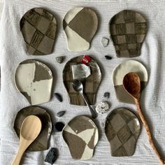 several pieces of broken glass and wooden spoons laid out on a white table cloth