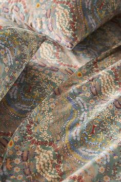 a close up view of a paisley print fabric with many different colors and patterns on it