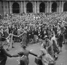 an old photo of people dancing in the street