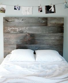 a wooden headboard with pictures hanging above it