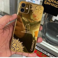 a person holding an iphone in their hand with gold foil on the back and side