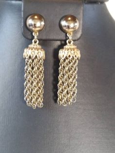 The Beautiful MONET Tassel Earrings are a great example of what made Monet pieces special. The quality, design and craftsmanship really shows. These earrings can be worn casually or easily dressed up for the office, even an evening out! The earrings are gold toned, with a round button at the top and a beautiful tassel hanging from it. The tassels have an intricate filigree design at the top with 10 Prince of Wales chains forming the tassel. I dated these around the late 1940s to early 50s as the Formal Metal Earrings With Latkans, Formal Dangle Tassel Earrings, Elegant Drop Clip-on Earrings With Latkans, Classic Metal Dangle Clip-on Earrings, Elegant Metal Tassel Earrings, Formal Metal Tassel Drop Earrings, Formal Earrings With Latkans, Formal Round Earrings With Latkans, Formal Round Latkan Earrings