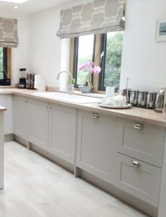 a large kitchen with white cabinets and counter tops is pictured in this image from the front view