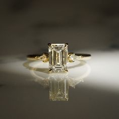 an emerald cut diamond ring with three side stones