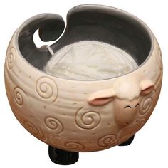 a ceramic sheep bowl with yarn in it