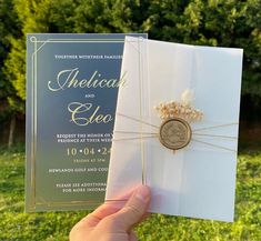 a person holding up a wedding card in their hand