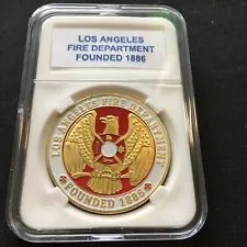 the commemorative medal for los angeles fire department is displayed in a clear plastic case on a black surface