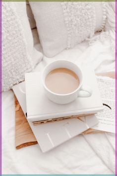 a cup of coffee sitting on top of two books