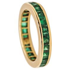 a gold ring with green stones on it