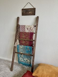 a ladder leaning against the wall with some blankets on it and a sign hanging above it