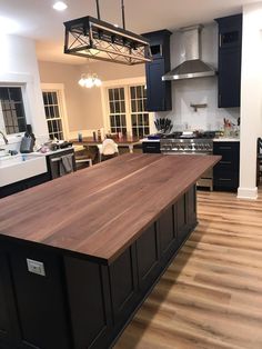 a kitchen with an island in the middle of it and lots of cabinets on both sides