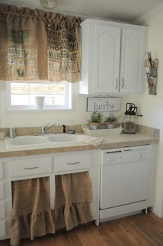 a kitchen with white cabinets and wooden floors is decorated in natural colors, such as burlap