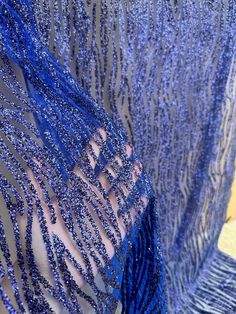 a woman wearing a blue dress with sequins on it