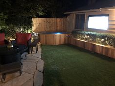 a backyard with a hot tub at night