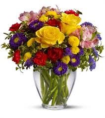 a vase filled with lots of colorful flowers