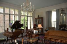 a living room filled with furniture and a grand piano