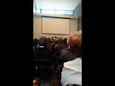 a group of people sitting in front of a projector screen