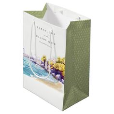 a green and white shopping bag with an image of the ocean on it's side