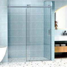 a glass shower door in a blue tiled bathroom