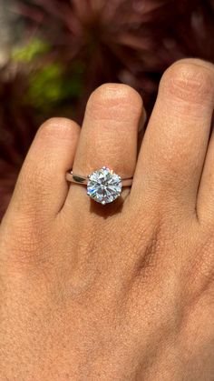 a person's hand with a diamond ring on it