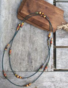 Bohemian Single Strand Lariat Beads, Bohemian Long Necklace With Wooden Beads As A Gift, Bohemian Single Strand Lariat Beaded Necklaces, Bohemian Single Strand Lariat Beaded Necklace, Bohemian Single Strand Beaded Necklaces For Layering, Bohemian Long Necklace With Wooden Beads, Bohemian Lariat Necklace With Tiny Beads, Colorful Czech Glass Bead Necklace For Festivals, Bohemian Lariat Jewelry With Tiny Beads